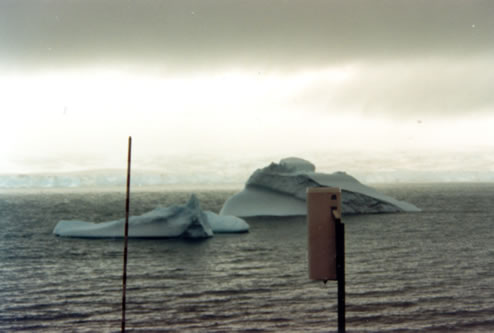 ANTARTIDA.  nuestro pluviómetro en primer plano, con iceberg al fondo.